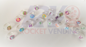 Anillos Letras Para Niñas Metal Juguete Encapsulado 1 pulgada 100 Pzas 1p - Rocket Vending Todo en Chicleras